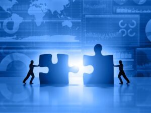 business-men-teamwork-joining-puzzle-on-blue-background